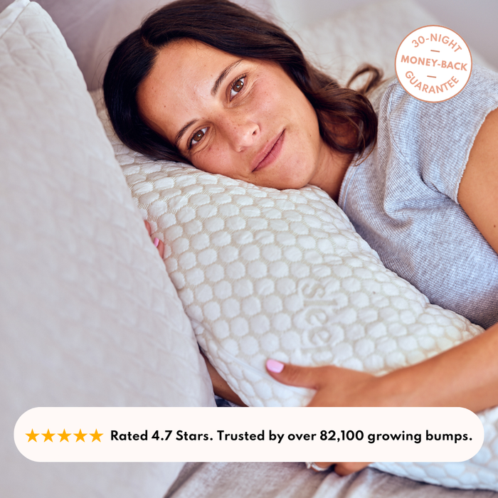 Woman resting on the Sleepybelly Pregnancy Pillow, rated 4.7 stars and trusted by over 82,100 growing bumps