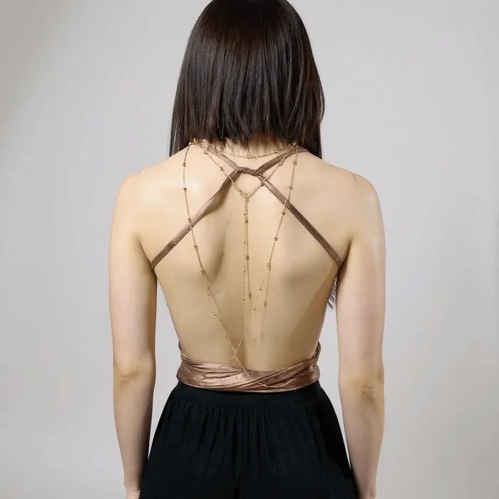 Sleeveless brown multi wrap halter top with plunging neckline, gold chain medallion, backless design, and extra-long ties styled for Y2K streetwear and festival fashion with body chain