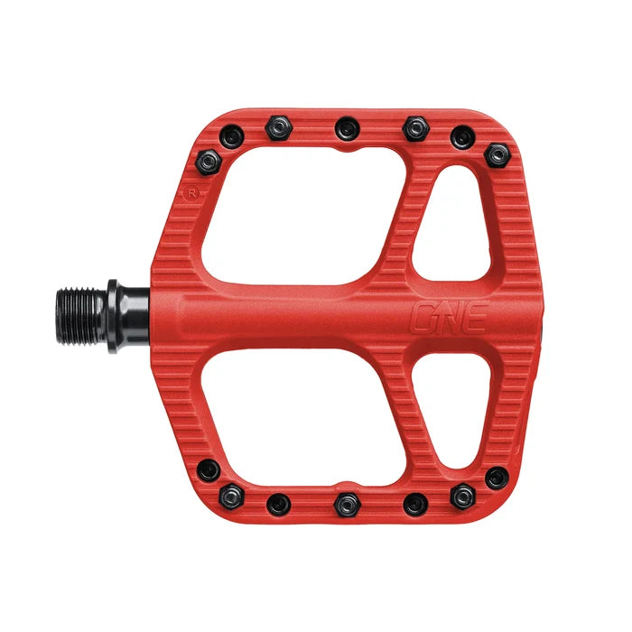 Red bicycle pedal with black bolts on a white background