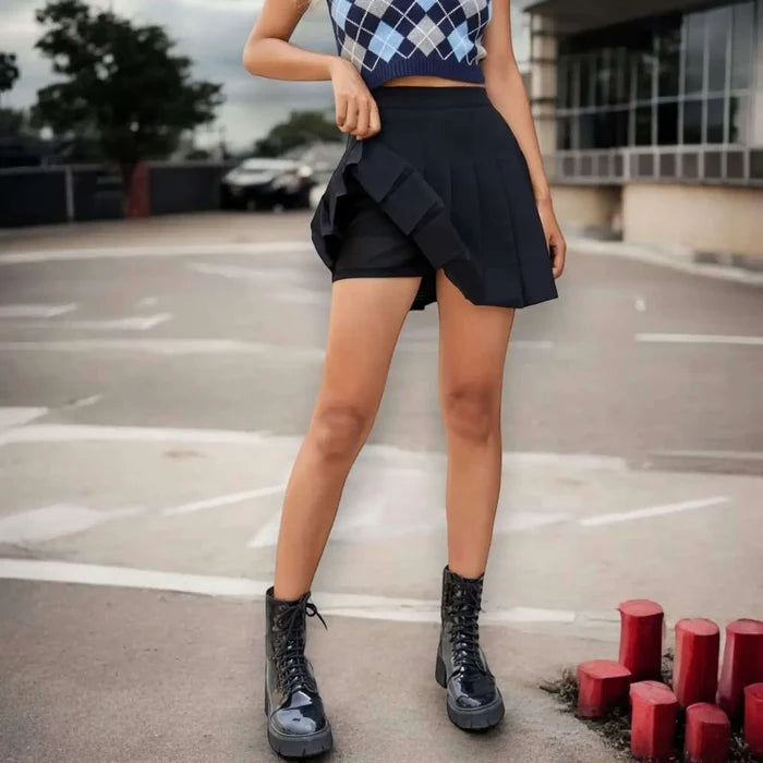 Solid pleated mini skirt in black with built-in shorts, high waist fit, and permanent pleats. Available in multiple colors. Y2K, schoolgirl, and punk-inspired.