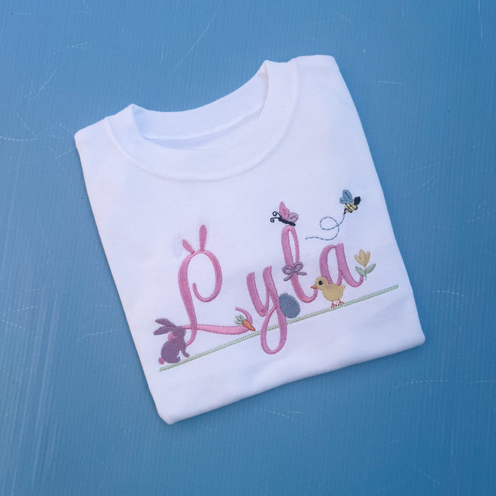 Name Lyla with lots of little Easter icons attached to it, Easter ears, bunny, carrot, bumble bee, flowers and chicks