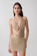Woman wearing a gold lurex cowl neck top.