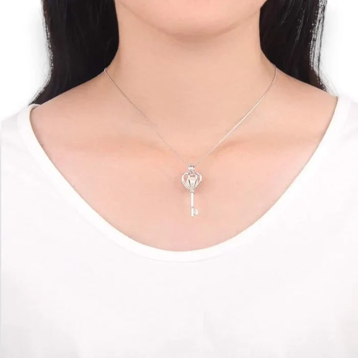 Sterling silver heart crown skeleton key pendant with faux pearl on dainty chain – necklace flat lay on neutral background