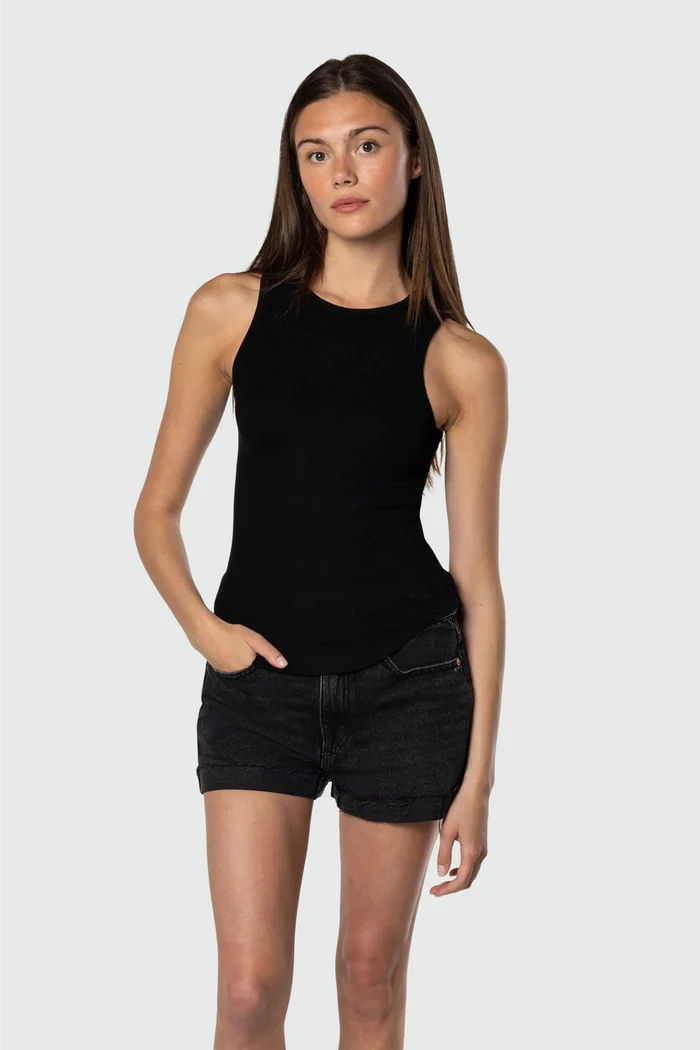 Woman wearing a black tank top and black shorts on a white background