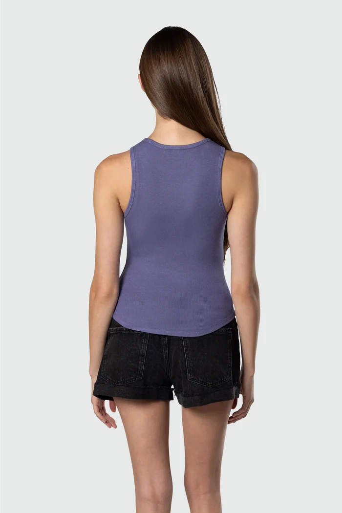 Woman wearing a purple tank top and black shorts on a white background