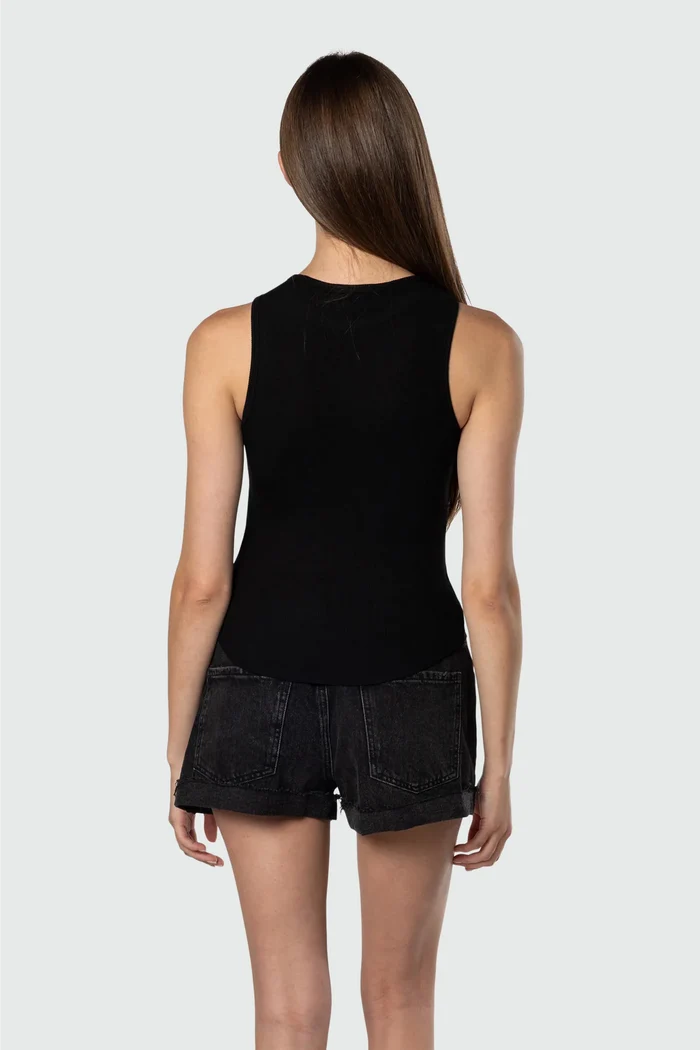 Person wearing a black sleeveless top and shorts on a white background