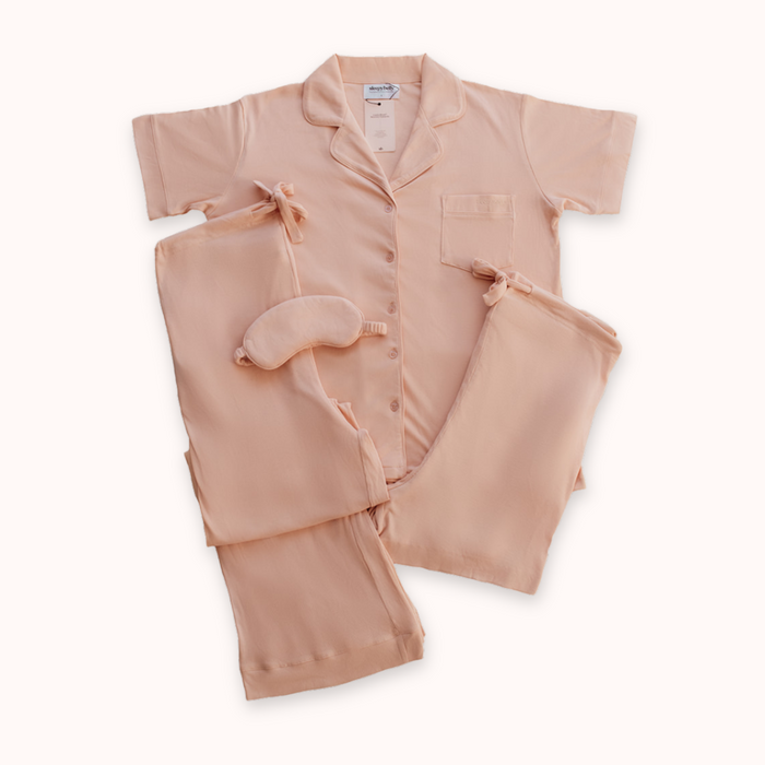 Blush pink maternity pyjama flat lay with eye mask and carry bag from the Sleepybelly Ultimate Sleep Bundle