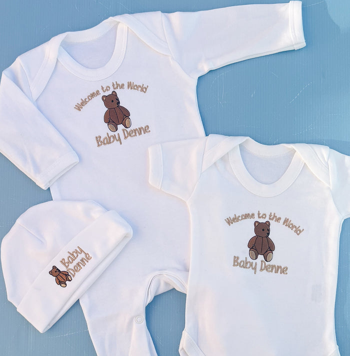 Close of f babygrow vest and hat with traditional bear embroidery