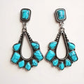 silver-plated turquoise teardrop western earrings on off white background