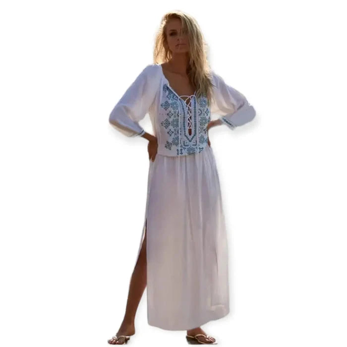 model wearing White Blue Embroidered Kaftan Dress with lace-up tassel neckline, long sleeves, smocked waist, and side splits