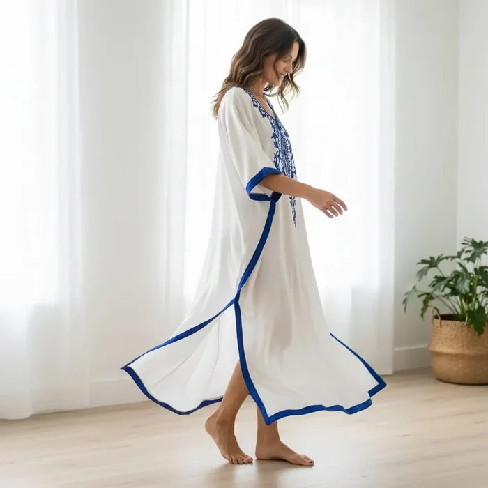 White Blue Embroidered Resort Kaftan worn by a woman in a bright room, showcasing its flowy design and embroidery.