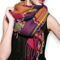 woman wrapped in a colorful multicolor plaid tassel blanket scarf styled as an oversized cozy wrap