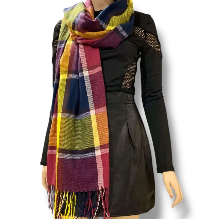woman wrapped in a colorful multicolor plaid tassel blanket scarf styled as an oversized cozy wrap