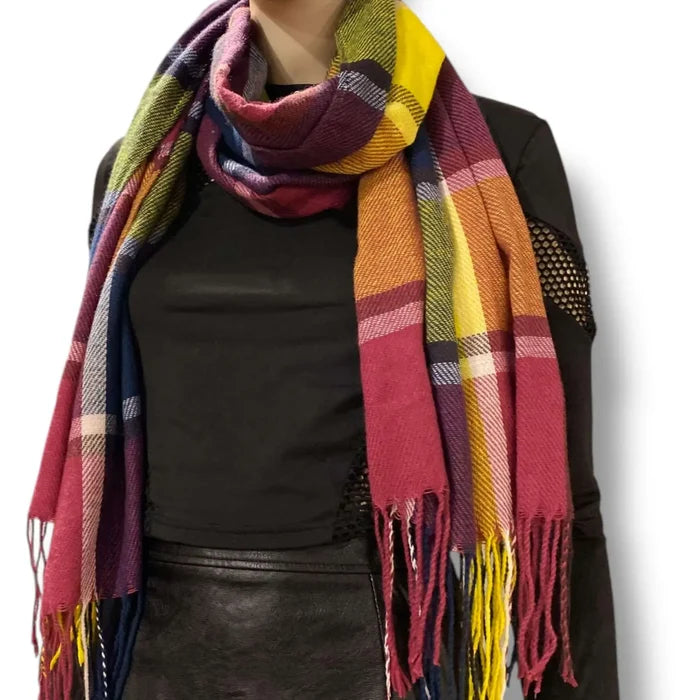 woman wrapped in a colorful multicolor plaid tassel blanket scarf styled as an oversized cozy wrap