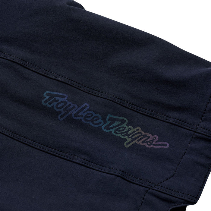 Close-up of a black garment with 'Troy Lee Designs' embroidery on a white background