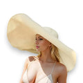 woman wearing the beige Women’s Oversized Brim Straw Sun Hat with dramatic 10-inch asymmetrical brim and woven straw beach style