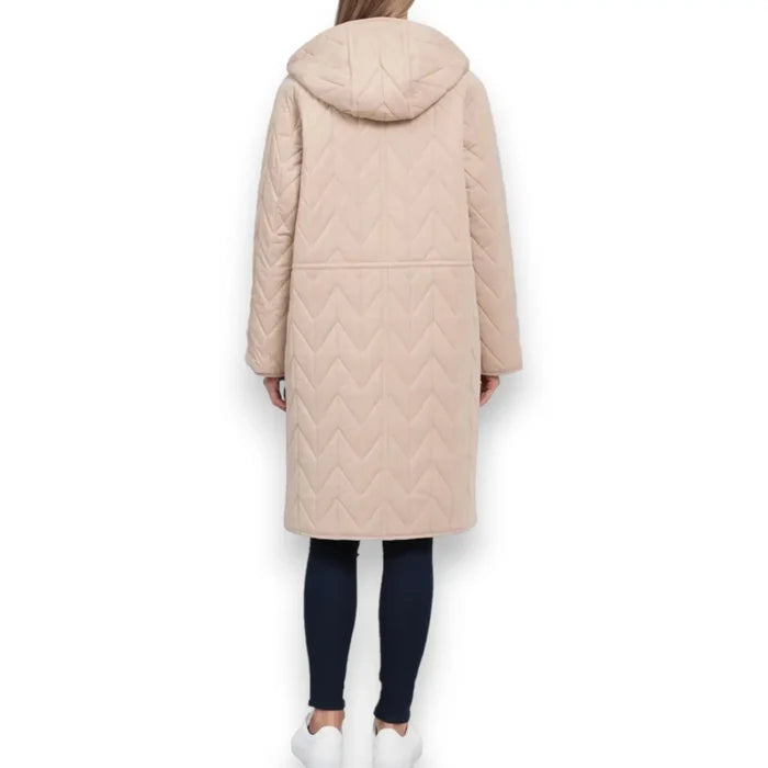 woman wearing back view of chevron quilting on mid-length tan anorak coat on white background
