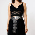 Women's wide leather disc statement belt with overlapping medallions, studs and engraved metal centerpiece