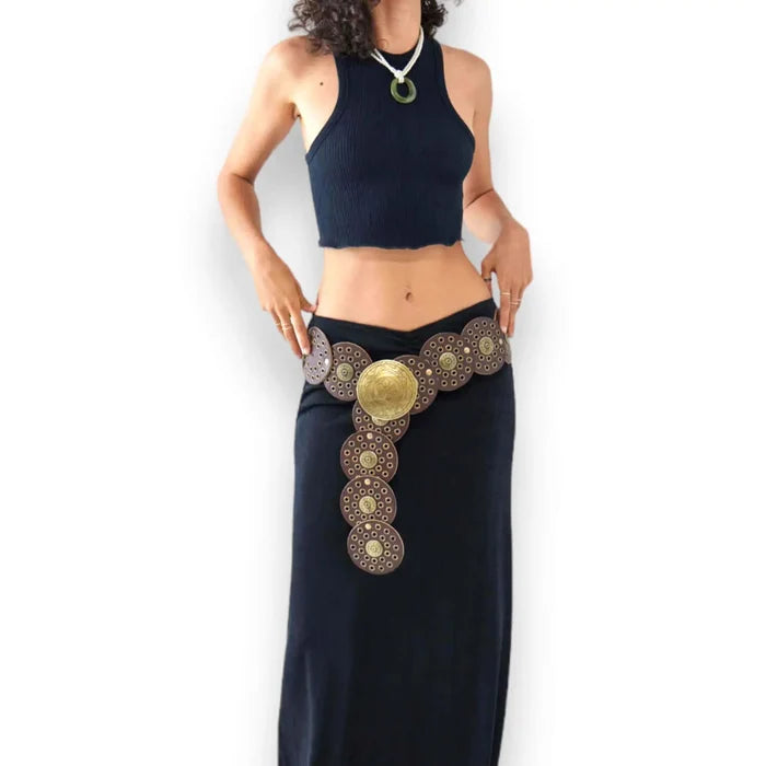 Women's wide leather disc statement belt with overlapping medallions, studs and engraved metal centerpiece